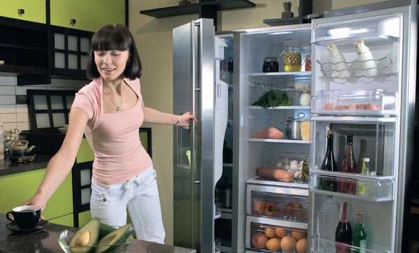  Nő kinyitotta a hűtőszekrény ajtaját