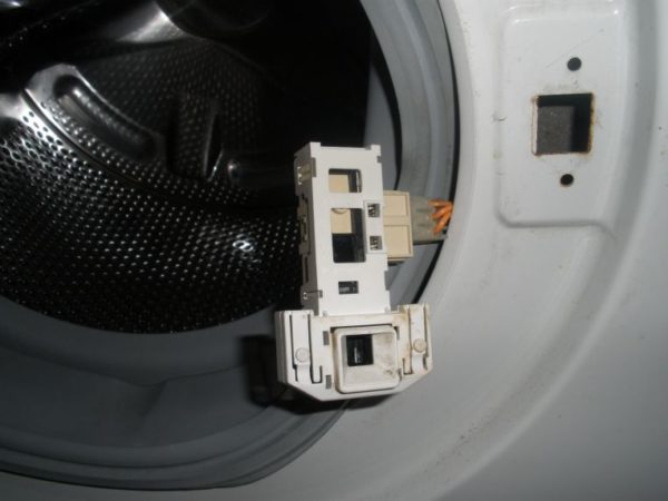  Enheten låser luckan i en tvättmaskin